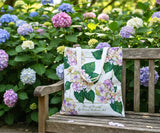 Hydrangea floral-patterned bag on a wooden bench with hydrangeas in the background 