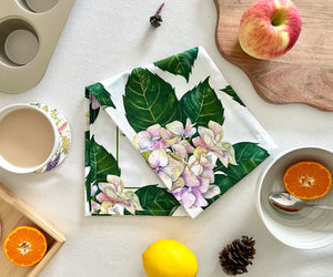 Folded hydrangea tea towel showing cotton texture and watercolour floral print.