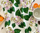 Front view of Hues of Serenity Hydrangea tea towel on table with soft floral design.