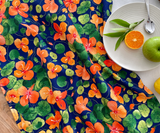 Front view of Nasturtium Dreams tea towel on a table, featuring bold watercolour nasturtiums.