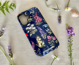 Angled view of wildflower iPhone case showing raised edge for camera protection and glossy finish