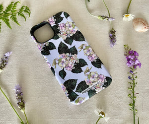 Angled view of the floral iPhone case showing sleek matte finish and soft hydrangea artwork.