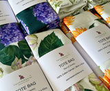 Collection of floral tote bags with visible branding and product details.